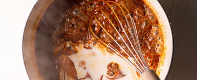 whisking homemade apple cider caramel in a saucepan