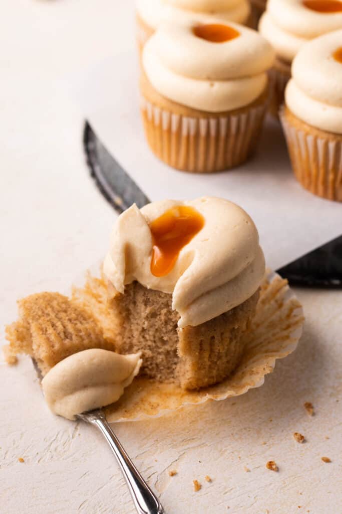 brown sugar cinnamon cupcake with a bite taken out of it and sitting on a board.