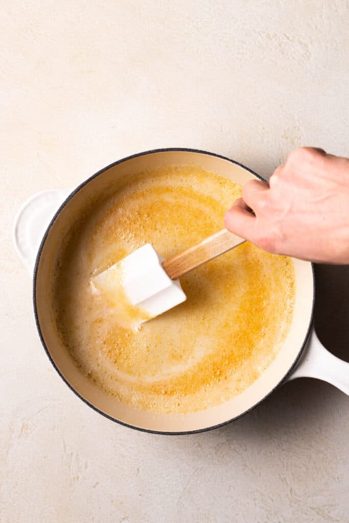 hand stirring browned butter with a rubber spatula