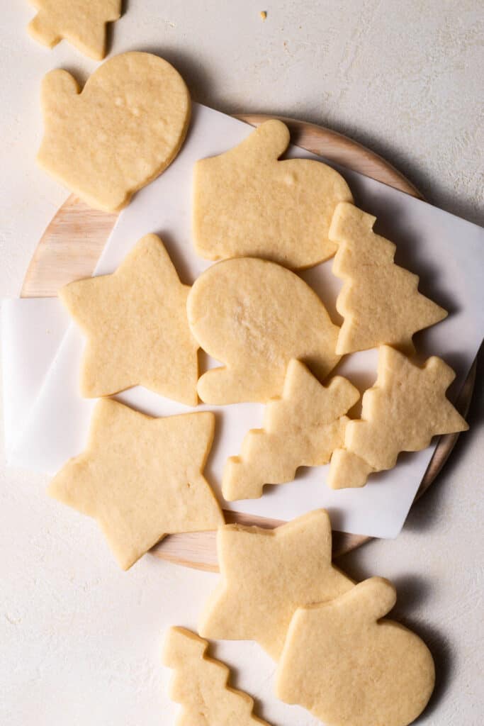 overhead shot of sugar cookie cut outs on a board with no frosting on them