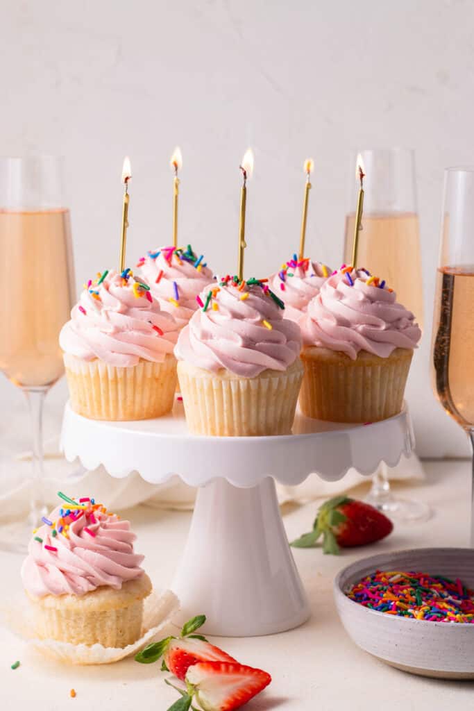 cupcakes on a cake stand with sparkling wine in background