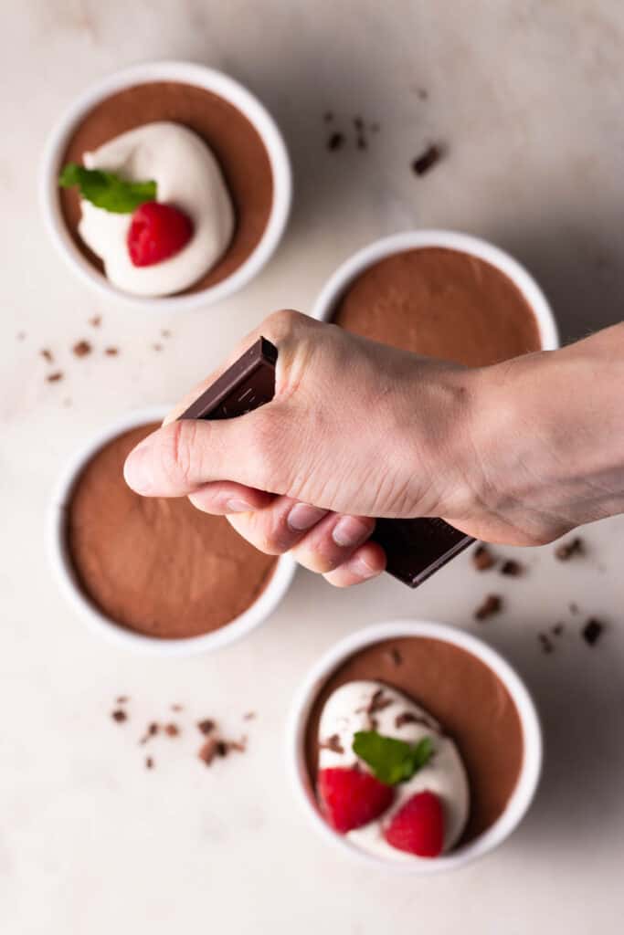 hand holding chocolate bar over chocolate mousse