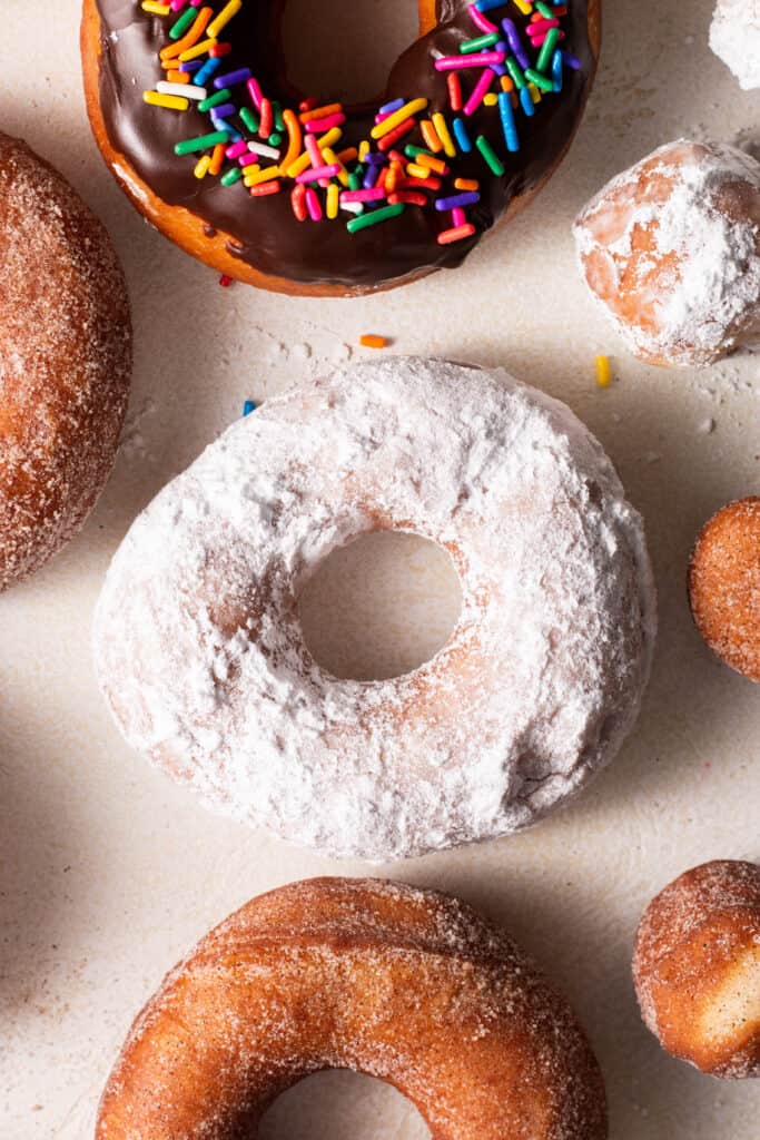 powdered sugar yeasted donut on a board.