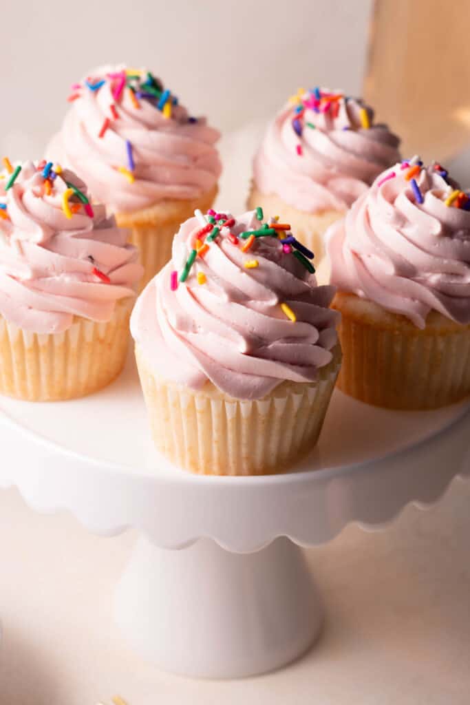 champagne cupcakes with strawberry swiss meringue buttercream on top