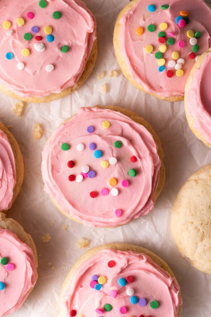 close view of a soft sugar cookies with pink buttercream frosting and sprinkles