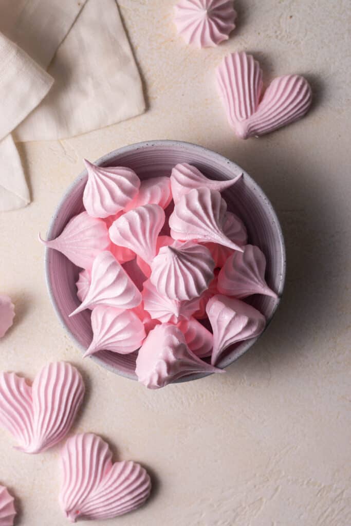 meringue cookies in a bowl on a surface