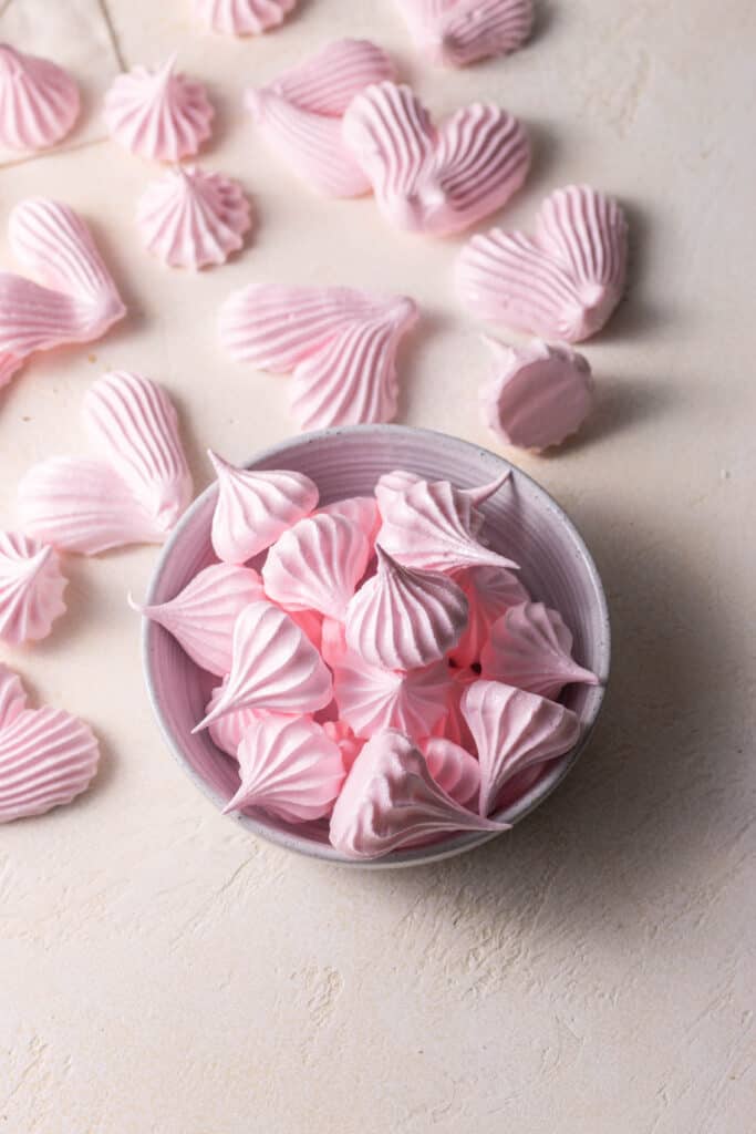 meringue cookies in a bowl on a surface