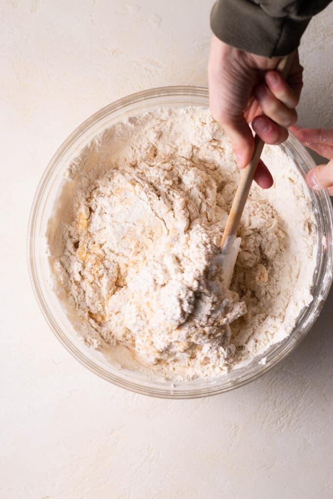 overhead shot of whisking dry ingredients into a bowl of mini skillet cookie dough.