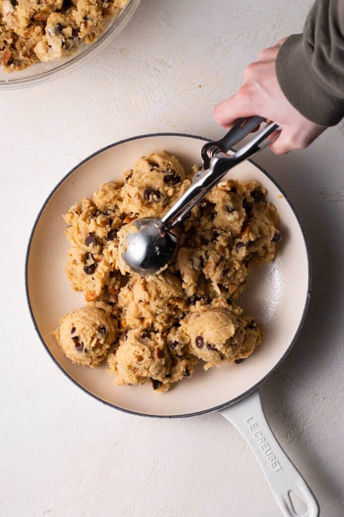 chocolate chip cookie dough being spooned into pan