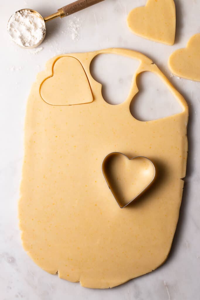 cut out shortbread cookie dough on a board with cookie cutter