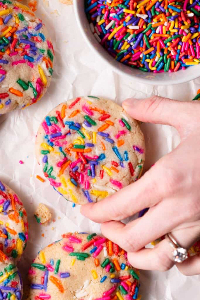 hand reaching for funfetti sugar cookie