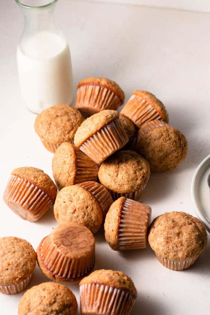 carrot cake muffins on a board with a glass of milk in the background