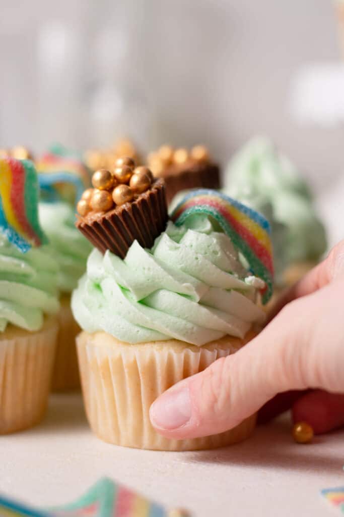 hand reaching for st. patrick's day cupcakes