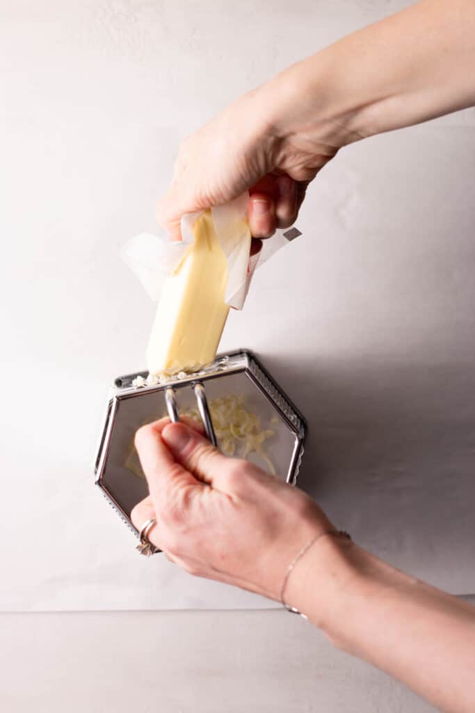 hand grating butter on a box grater