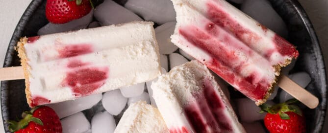 strawberry cheesecake popsicles on a surface
