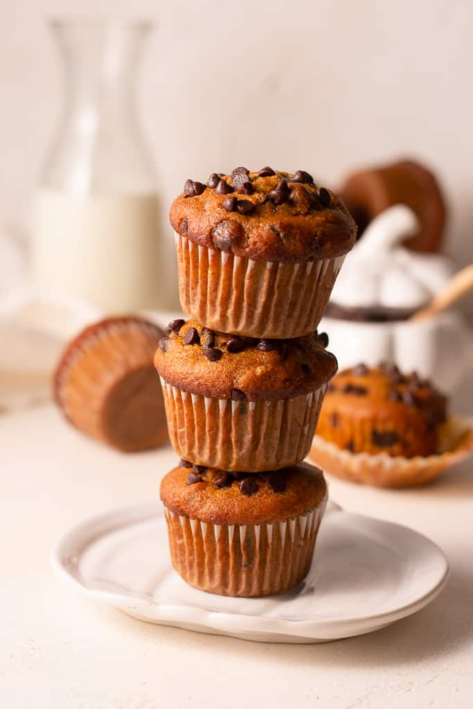 3 pumpkin muffins stacked on top of each other sitting on a plate