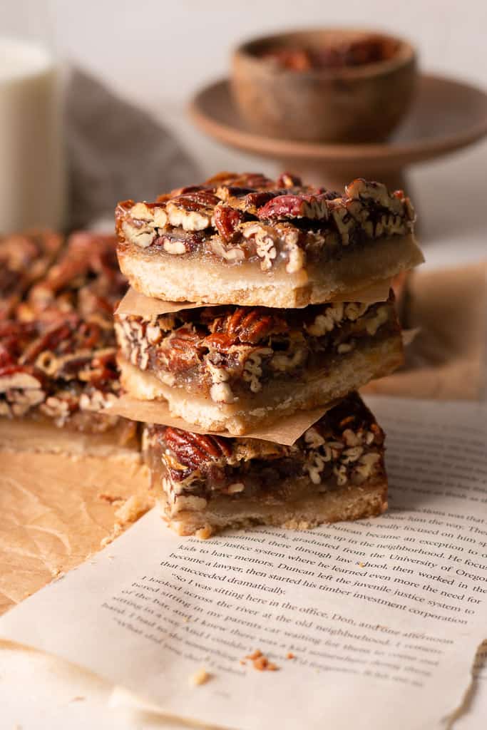 pecan pie shortbread bars stacked on top of each other.