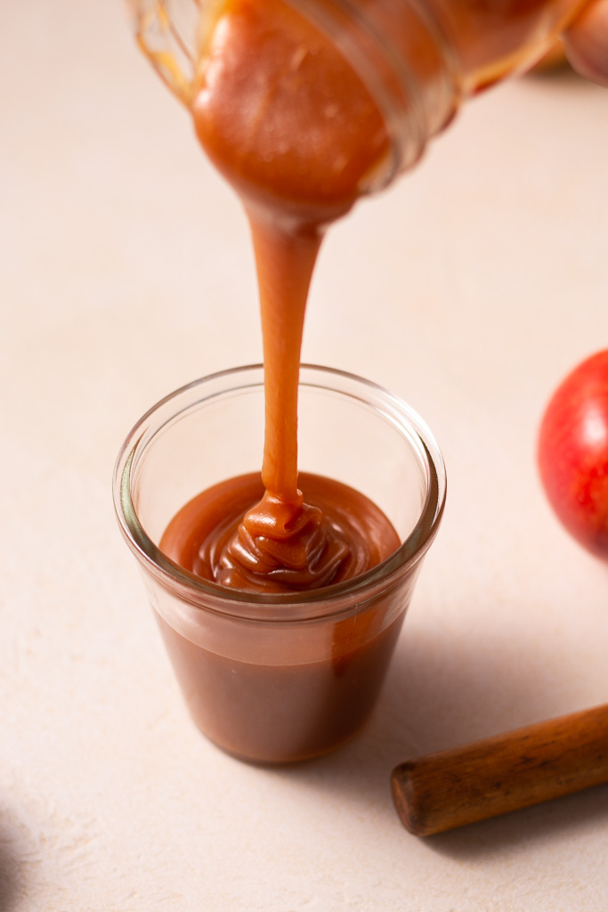 side shot of pouring caramel into a glass container