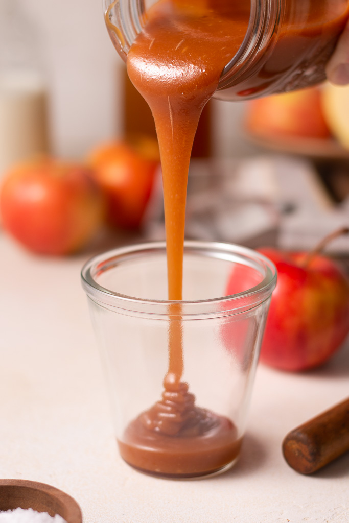 apple cider caramel being poured into a glass jar