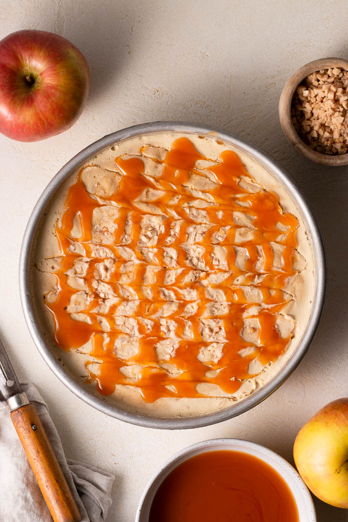 overhead shot of caramel apple ice cream in a round cake pan with caramel swirled on top