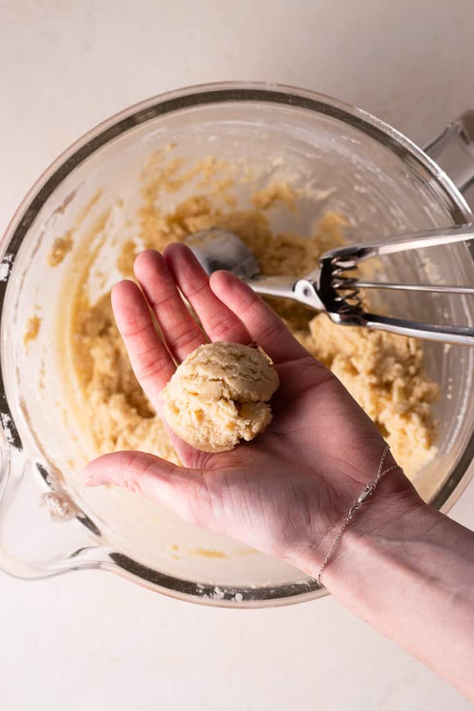 rolling soft sugar cookie recipe dough into balls before baking