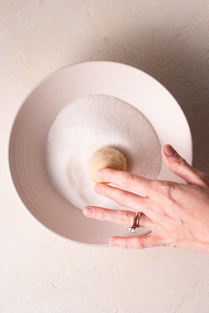 hand rolling dough in granulated sugar.