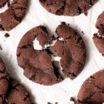 chocolate marshmallow cookie on a board and being pulled apart.