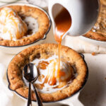 homemade caramel being poured over mini skillet cookies.