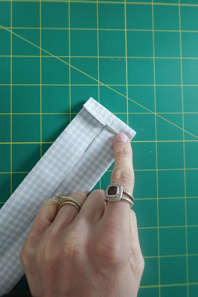 folding short edge in 1/4-inch to enclose the raw edge.