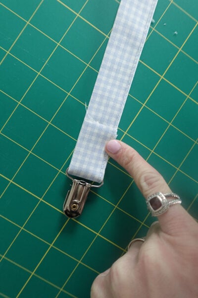 folding the fabric back from the suspender clip.