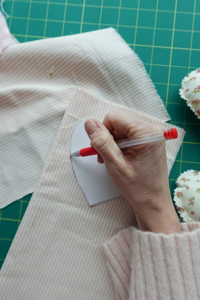 tracing heart onto fabric.