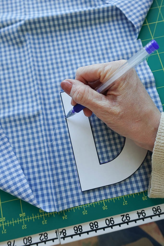 tracing letters onto fabric.