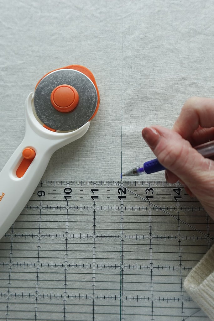 using a rotary cutter to cut fabric.